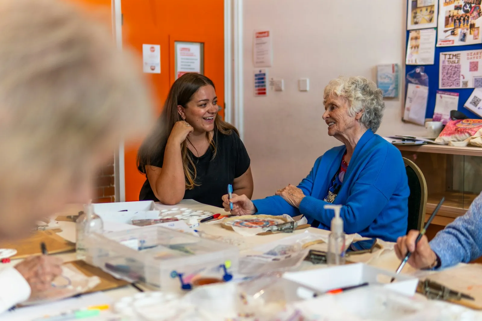 A young woman and an older woman chatting during an art activity