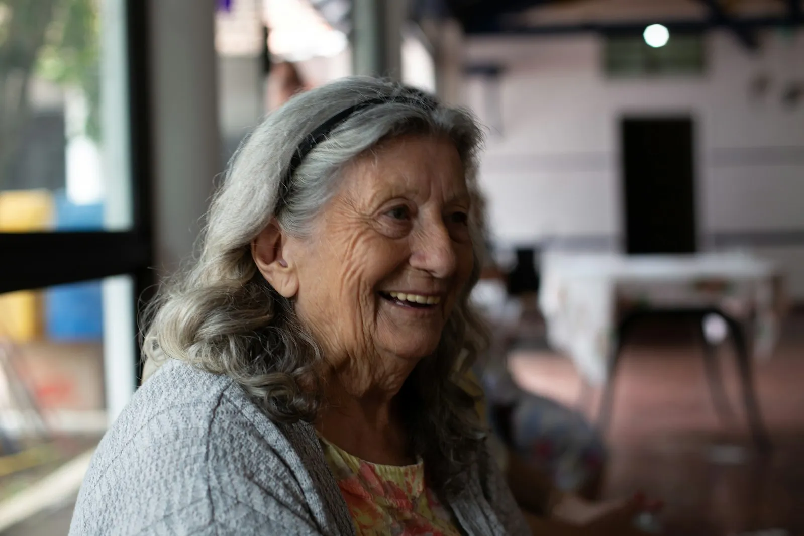 An older woman with long gray hair laughing