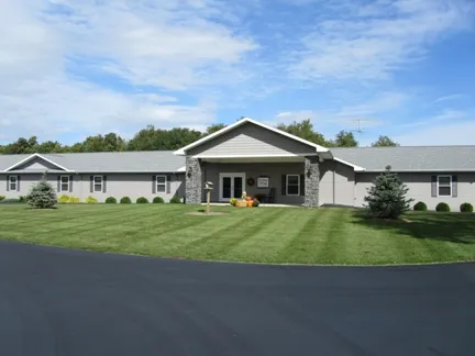 Country Living of Hillsdale: a single-story home with a stone entry, set on a wide green lawn