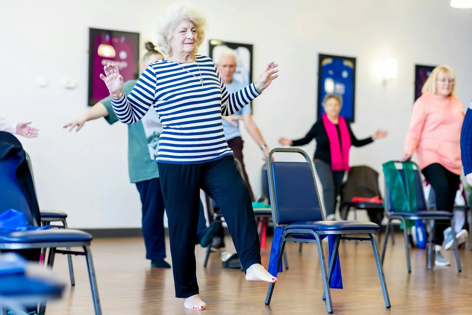Older women smiling and stretching their arms in an exercise class