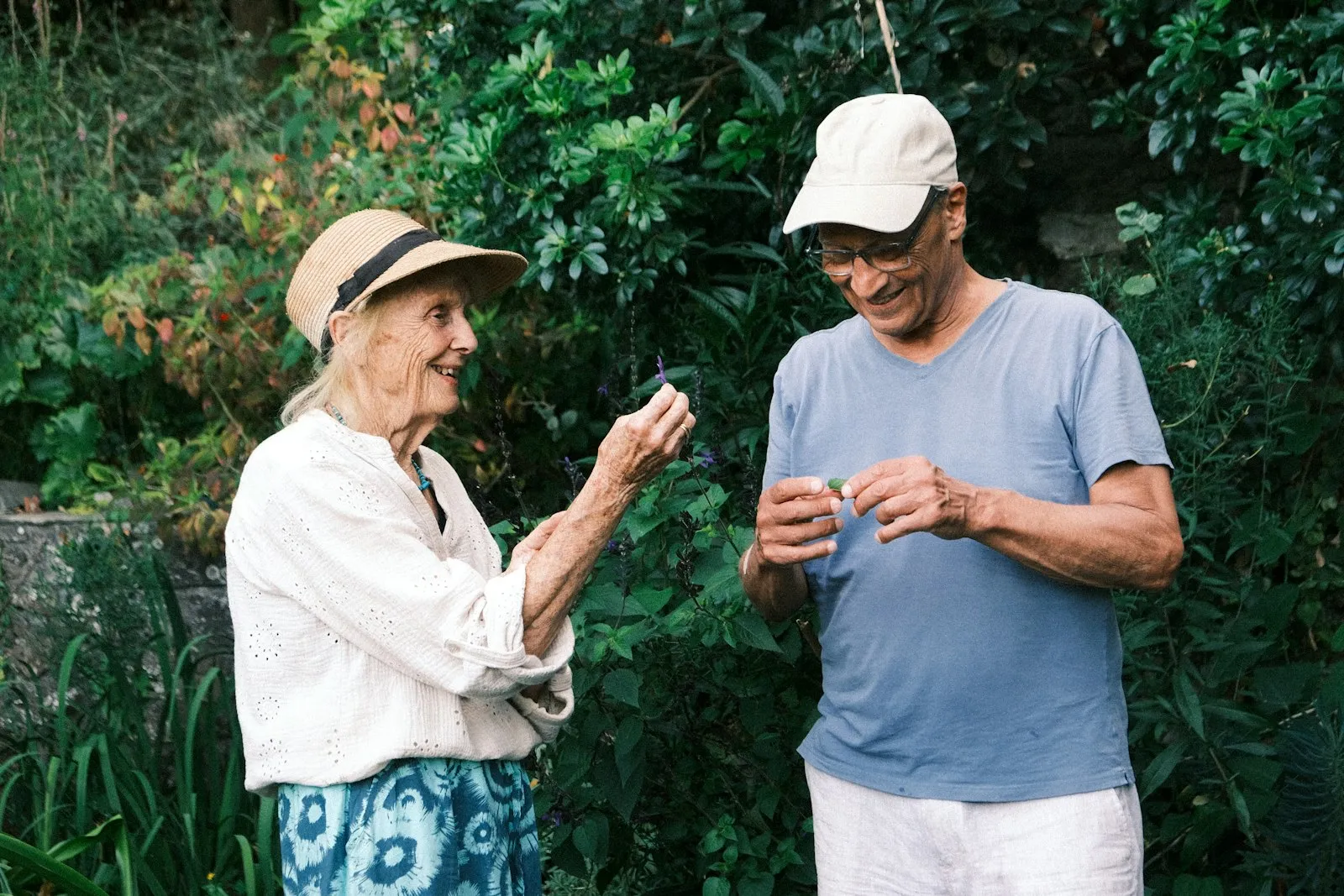 An older woman and man laughing together in a green garden